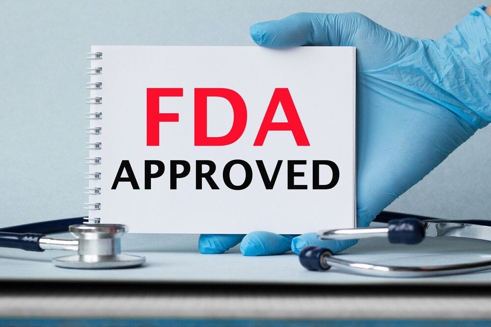 Physician’s hand holding FDA approval sign